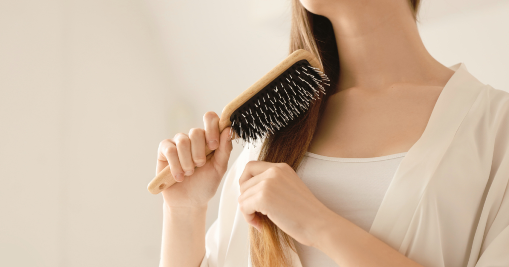 大人女性が髪を整えるために正しいブラッシングをしている様子
