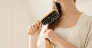 大人女性が髪を整えるために正しいブラッシングをしている様子